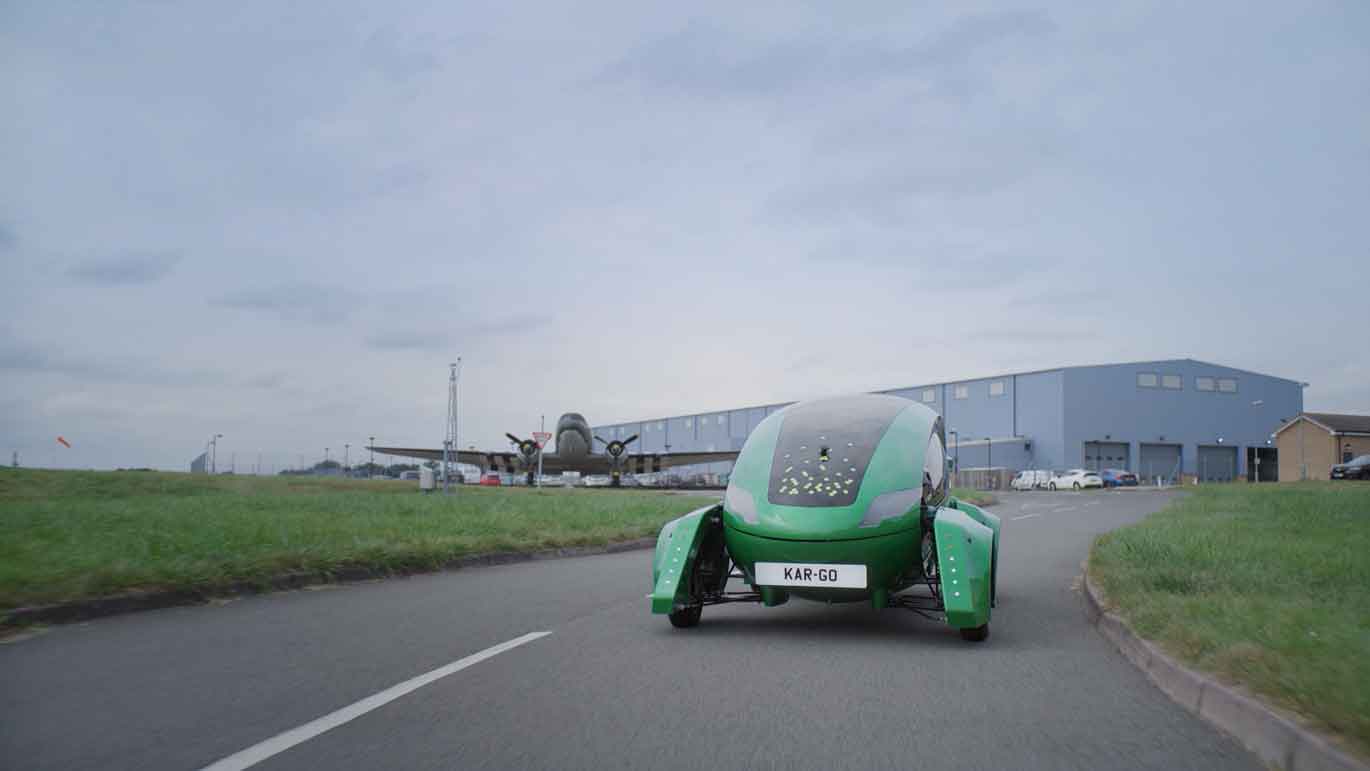 Image shows electric car on a road.
